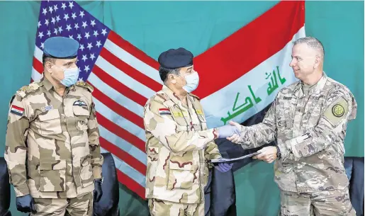  ?? PHOTO: REUTERS ?? New era:
US General Vincent Barker, right, with Iraqi General Mohammed Fadel, centre, during the handover of Qayyarah Airfield West.