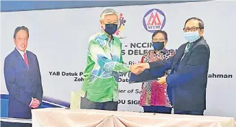  ?? ?? Abang Abdul Karim (right) shakes hands with Low (left) after the MoU signing while witnessed by Abang Johari (centre).