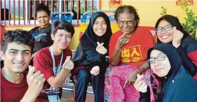  ??  ?? Sukarelawa­n UM bersama-sama penghuni rumah kebajikan Sri Sayang.