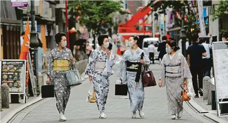  ?? REUTERS ?? Geisha. Maki, Mayu, Koiku and Ikuko wear protective face masks as they walk to a restaurant after attending a dance class