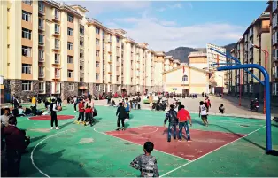  ?? Photo by Ake Jiushe ?? Children playing on the playground in front of their new homes in the relocation settlement of Zhaojue County, Sichuan Province.