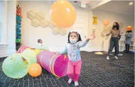  ?? ?? Damorah Martin chases a balloon after crawling through a tunnel in the music room during the “My Wonder Kids” program at A House in Austin on Nov. 11. A House in Austin is an informal space for West Side parents to meet each other, learn new skills and share experience­s.