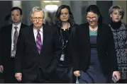  ?? ALEX WONG / GETTY IMAGES ?? U.S. Senate Majority Leader Sen. Mitch McConnell, R- Ky., walks towards the Senate chamber with aides after the House passed a bill to temporaril­y fund the government through Jan. 19.