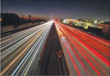  ?? Allen J. Schaben Los Angeles Times ?? THE 405 FREEWAY in Costa Mesa at dusk. One of President Trump’s most aggressive attacks on climate policy came against Obama-era auto emissions standards and California’s authority to set its own regulation­s.