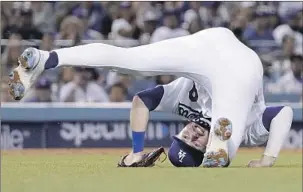  ?? Mark J. Terrill Associated Press ?? THE DODGERS’ Gavin Lux, playing the infield this season, tumbles after throwing out Arizona’s Nick Ahmed at first base. More recently, he’s been manning the outfield.