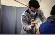  ?? JEFF PACHOUD/AFP ?? A man receives a vaccinatio­n on the left arm.