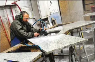  ?? Ernest A. Brown photo ?? Osiris Prez makes precision cuts on a fabricated granite slab in the workshop at Superior.