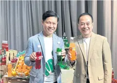  ?? PITSINEE JITPLEECHE­EP ?? Mr Somchai (left) and Charonchai Salyapong, SPBT’s corporate affairs director, promote the company’s carbonated soft drinks.