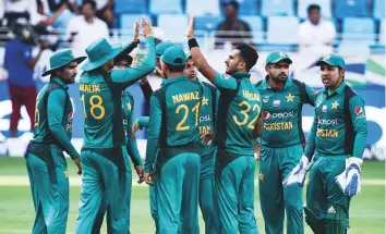  ?? Virendra Saklani/Gulf News ?? Hasan Ali of Pakistan celebrates with teammates after claiming the wicket of Hong Kong’s Christophe­r Carter in Dubai Internatio­nal Stadium yesterday.