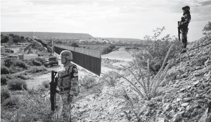  ?? REUTERS ?? Soldiers assigned to the National Guard keep watch near a section of the border fence between Mexico and U.S. as seen from Anapra neighborho­od in Ciudad Juarez, Mexico Sept. 5.