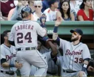  ?? ELISE AMENDOLA — THE ASSOCIATED PRESS ?? Detroit Tigers’ Miguel Cabrera (24) receives congratula­tions at the dugout after his solo homer in the ninth inning of a baseball game against the Boston Red Sox at Fenway Park on Wednesday in Boston. The Tigers won 4-3.