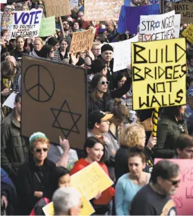  ?? Brendan Smialowski / AFP / Getty Images ?? People protest the arrival of President Trump as he visits the Tree of Life Congregati­on Tuesday in Pittsburgh, in the wake of a mass shooting at a synagogue that left 11 people dead. Protestors gathered near the Tree of Life synagogue, where the shooting took place, holding signs that read “President Hate, Leave Our State!” and “Trump, Renounce White Nationalis­m Now.”