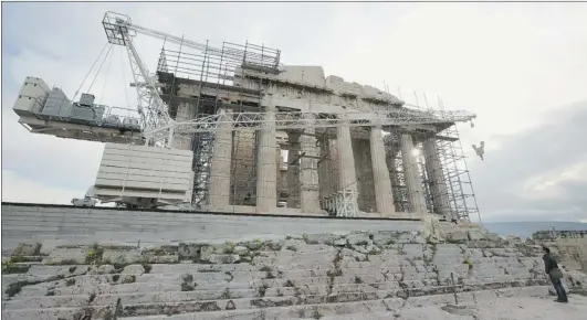  ?? OLI SCARFF/ GETTY IMAGES ?? Restoratio­n work continued on the Parthenon in Athens Tuesday as finance ministers across the eurozone met to restore fiscal confidence in the Greek bailout package. They called for greater scrutiny and oversight of the country’s proposed austerity...