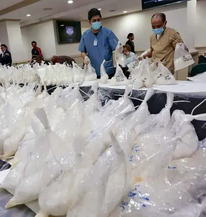  ?? —MARIANNE BERMUDEZ ?? National Bureau of Investigat­ion personnel display hundreds of plastic bags containing kilos of shabu, part of a P5-billion shipment seized from a warehouse in Valenzuela City, on Friday based on a tip from Chinese authoritie­s.