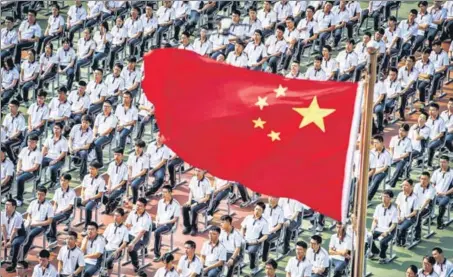  ?? AFP ?? Students attend the 100th anniversar­y of the founding of Wuhan High School on the first day of the new semester in the Chinese city on Tuesday.