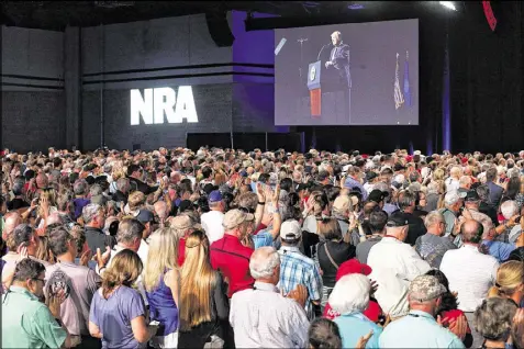  ?? CURTIS COMPTON / CCOMPTON@AJC.COM ?? Thousands of NRA attendees watch the keynote by President Donald J. Trump on one of the giant screens in Hall A at the NRA-ILA Leadership Forum on Friday in Atlanta.