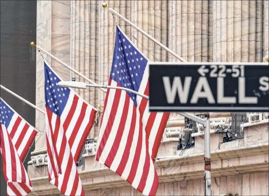  ?? Frank Franklin II / Associated Press ?? American flags hang outside of the New York Stock Exchange as the stock market closed out a choppy week with the major indexes finishing in the red for the week.