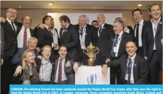  ??  ?? LONDON: The winning French bid team celebrate around the Rugby World Cup trophy after they won the right to hold the Rugby World Cup in 2023, in London, yesterday. Three competing countries South Africa, Ireland and France bid for the rights to hold...