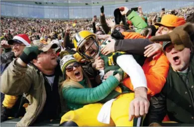  ?? MATT LUDTKE - THE ASSOCIATED PRESS ?? Green Bay Packers quarterbac­k Aaron Rodgers celebrates his touchdown run with fans during the first half of an NFL football game against the Minnesota Vikings Saturday in Green Bay, Wis.