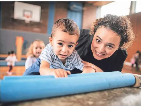  ?? FOTO: RALPH MATZERATH ?? Kindertage­spflegerin Soumaya Mallal und ihr Schützling Yasin genießen die gemeinsame Turnstunde. Einmal in der Woche geht es zum Sport.