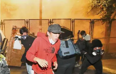  ?? Marcio Jose Sanchez/Associated Press ?? Demonstrat­ors back away from tear gas during a Black Lives Matter protest at the Mark O. Hatfield United States Courthouse on July 23, 2020, in Portland, Ore. More than 119,000 people have been injured by tear gas and other chemical irritants around the world since 2015 and some 2,000 suffered injuries from “less lethal” impact projectile­s, according to a new report released Wednesday.