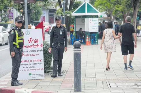  ?? PAWAT LAUPAISARN­TAKSIN ?? Tessakit officers patrol an area in Klong Toey to stop people driving motorcycle­s on pavements.