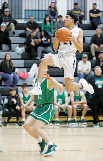  ?? LUIS SÁNCHEZ SATURNO/THE NEW MEXICAN ?? Capital’s T.J. Sanchez flies past Albuquerqu­e’s Jude Tapia during the first quarter of Tuesday’s game at Capital. The Jaguars won, 69-62.