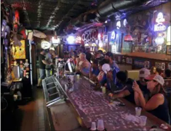 ?? CHUCK BURTON — THE ASSOCIATED PRESS ?? Locals have a drink as they relax at the Barbary Coast bar in downtown Wilmington, N.C., as Florence threatens the coast Thursday.