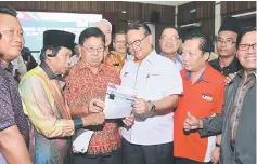  ??  ?? Nanta (fifth right) shows the Village Administra­tion Certificat­e Programme closing ceremony leaflet to community leaders.