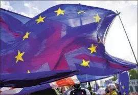  ?? Alberto Pezzali Associated Press ?? A UNION JACK waves behind a European Union f lag outside the Houses of Parliament. The U.K. is trying to improve ties with the bloc after years of acrimony.