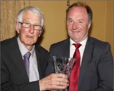  ??  ?? Nicky Newport of St. Fintan’s is presented with his hall of fame award by Derek Kent (Co. Chairman).