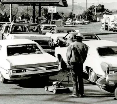  ?? ASSOCIATED PRESS ?? Drivers and a man pushing a lawnmower line up at gas station in San Jose in March 1974 due to nationwide gasoline shortages prompted by an Arab oil embargo. The S&P 500 tumbled 29.7 percent in 1974 as inflation shot up to 12.1 percent.