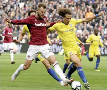  ?? — AP ?? Andriy Yarmolenko ( left) of West Ham vies for the ball with Chelsea’s David Luiz during their English Premier League match at London Stadium in London on Sunday.