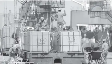  ?? REUTERS ?? Workers load goods for export onto a crane at a port in Lianyungan­g, Jiangsu province, China June 7, 2019. China’s trade with the United States sank in November as negotiator­s of the two giant economies worked on the first stage of a possible deal to end the tariff war.