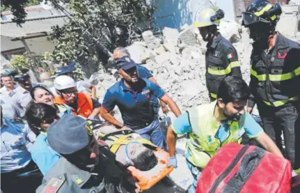  ?? ANSA ?? Ciro Toscano, 11, is carried on a stretcher Tuesday from a collapsed building in Casamiccio­la, Italy, a day after a 4.0-magnitude quake hit the Italian resort island of Ischia. Ciro and his two brothers were rescued from the rubble of their home.