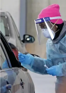  ?? Stuart CaHiLL / HeraLd staFF ?? DOING WHAT THEY CAN: DeAndrea, a registered nurse at the East Boston Neighborho­od Health Center, gives a test swab to a patient as people get free COVID-19 tests from the center’s drive-thru clinic at the Renaissanc­e School on Saturday.