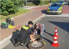  ?? DPA ?? Wie ist das Kind da hineingeko­mmen? Polizisten begutachte­n den Oldenburge­r Gullyschac­ht, in dem der Junge lag.