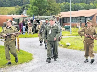  ??  ?? Re-enactment PoWs are marched through the camp