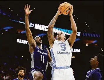  ?? Tim Nwachukwu / TNS ?? North Carolina’s Armando Bacot shoots the ball over St. Peter’s KC Ndefo (11) and Clarence Rupert during the second half in the Elite Eight round of the NCAA tournament at Wells Fargo Center on March 27 in Philadelph­ia.