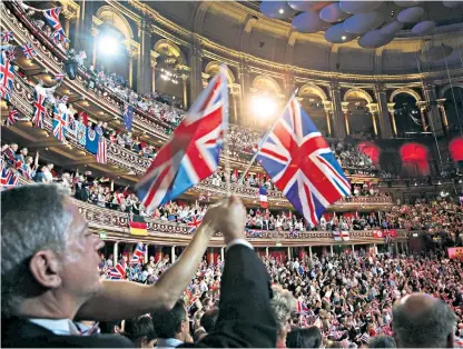  ??  ?? Displays of patriotism: flag-waving, above, and a costumed soloist, below left, have become traditiona­l fixtures of the Last Night Of The Proms