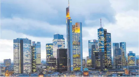  ?? FOTO: DPA ?? Die Hochhäuser und Bankentürm­e des Frankfurte­r Finanzbezi­rks: Europäisch­e Institute arbeiten noch immer die Altlasten der Finanzkris­e ab, während die Banken der Wall Street das durch die für sie günstige US-Politik schon lange hinter sich haben.
