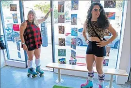  ??  ?? SHAYNA MEIKLE, a.k.a. “Pigeon,” left, and Amy West, a.k.a. “Indy Jamma Jones,” hang out in the Moxi store in Venice while decked out in their skating gear.