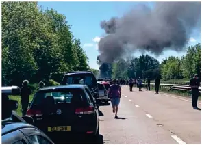  ??  ?? Above: Rescuer Daniel Nicholson, left, and pilot Stuart Moore. Left: Drivers come to a halt as smoke rises from the A40