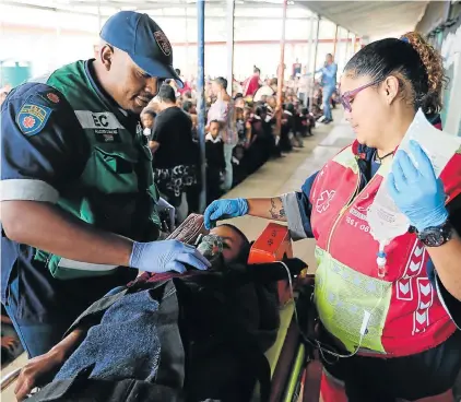  ?? Picture: WERNER HILLS ?? MOCK RESCUE: Ambulance staffers Allister Commons, left, and Sydney Burgins with ‘distressed pupil’ Ashwin Koopman, 9, on a stretcher