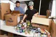  ?? Ned Gerard / Hearst Connecticu­t Media ?? Scouts Emilio Contreras, left, and Matt Wright sort food items being collected during Boy Scout Troop 1’s food drive at Wasson Field in Milford on Friday.