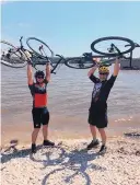  ?? COURTESY OF KEVIN MAININI ?? Kevin Mainini, left, and his father, Chris, of Albuquerqu­e, celebrate after completing their bicycle trek across Iowa in 2019.