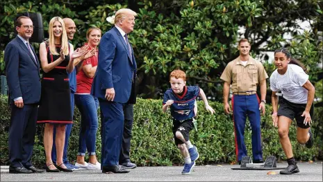  ?? OLIVIER DOULIERY / ABACA PRESS ?? President Donald Trump, with daughter Ivanka Trump (left, clapping), watches kids participat­e in races during the White House Sports and Fitness Day on the South Lawn on Wednesday in Washington.