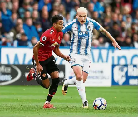  ?? — Reuters ?? The underdog: Huddersfie­ld’s Aaron Mooy (right) vying for the ball with Manchester United’s Jesse Lingard during their English Premier League match at John Smith’s Stadium in Huddersfie­ld yesterday.