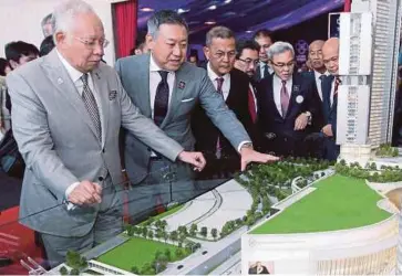  ??  ?? NAJIB mendengar penerangan daripada Pengarah Urusan Mitsui Fudosan Asia Malaysia & MFBBCC Retail Mall Sdn Bhd, Takehito Fukui (dua dari kiri) ketika melihat model pembanguna­n BBCC di Kuala Lumpur, semalam.