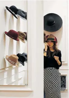  ?? Photos / AP ?? Left, and far left, women check out the latest hats inside a Borsalino store in downtown Milan. The company used to make hats for men only but is now diversifyi­ng into the female market.